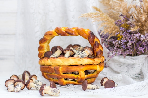 Cookies mushrooms glazed in white and brown chocolate in wicker basket of dough. Dessert. Beautiful sweet