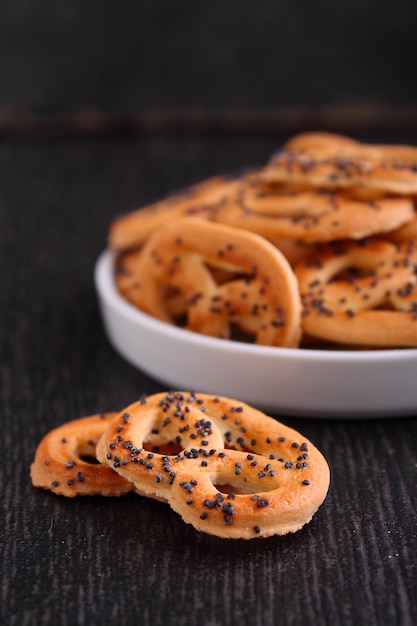 Cookies pretzels with poppy seeds on a black background