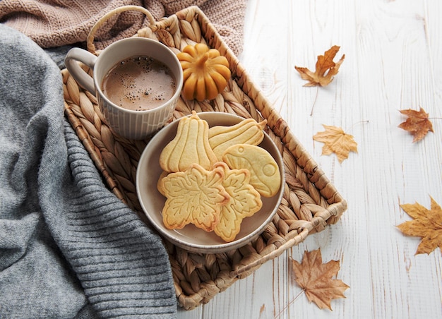 Cookies shaped like pumpkin and leaves on rustic wood background