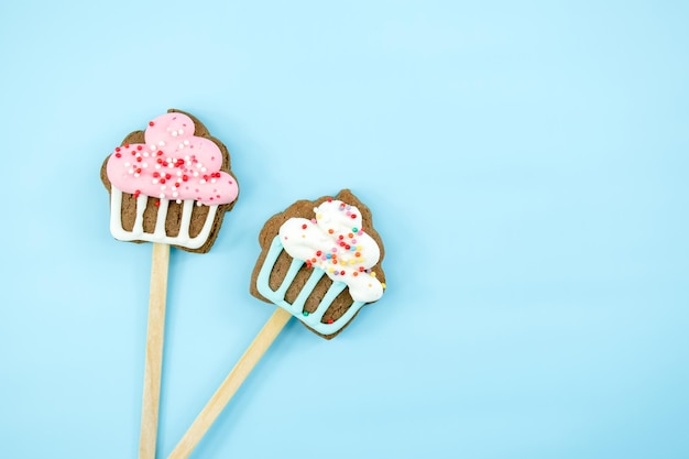 Cookies on a stick with pastry sprinkles on a blue background Delicious sweets top view