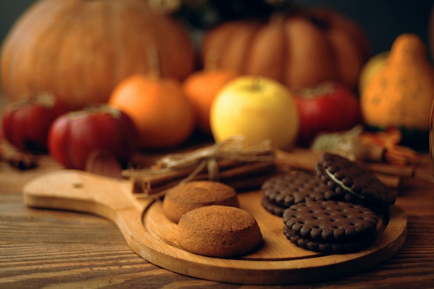 Photo cookies with pumpkins and apples on the table.