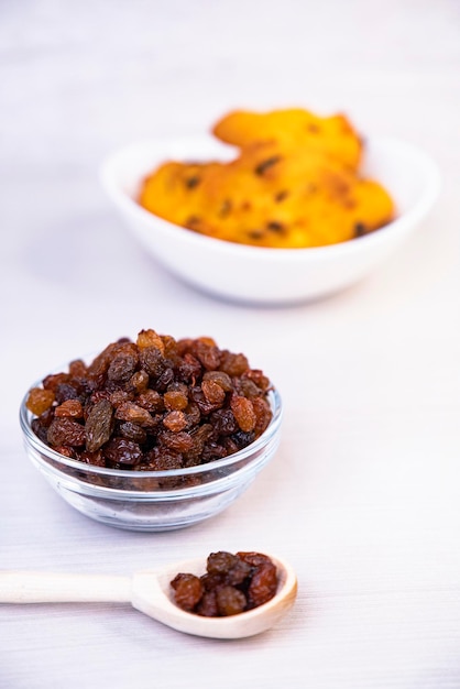 Cookies with raisins in a bowl on a wooden background baking vertical frame