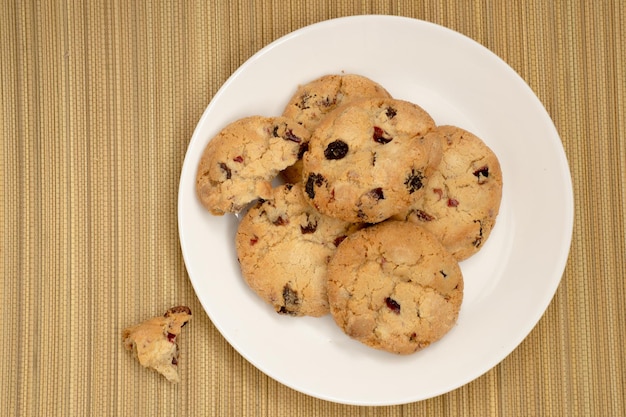 Cookies with raisins on the plate on straw mat