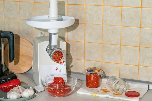 Cooking adjika from hot pepper and garlic ground in a meat grinder preparations for the winter folk remedy for flu and colds