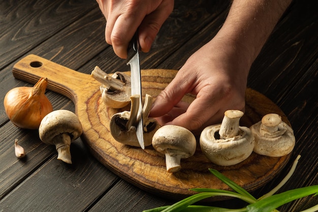 Cooking Agaricus mushrooms by the hands of the chef in the kitchen Grande cuisine