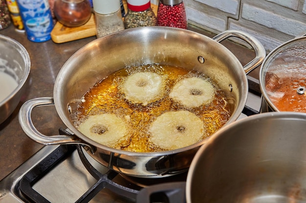 Cooking apple pancake Apple donut in boiling oil