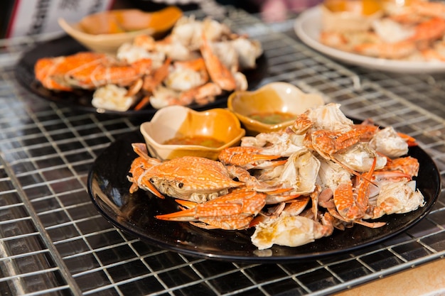 cooking, asian kitchen, sale and food concept - crabs dish at street market