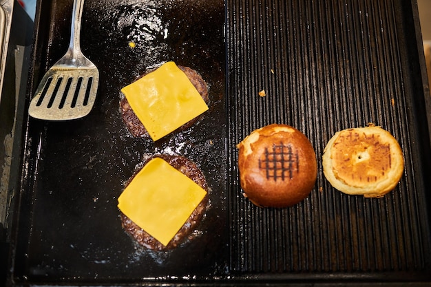 Cooking beef burger patties on a frying surface. burgers.