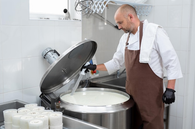 Cooking cheese from a private cheese factory A man cuts raw materials with a large knife