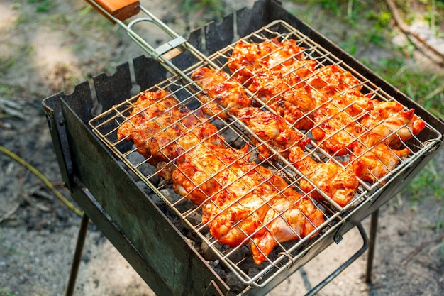 Cooking chicken wings and legs on the grill Roasted meat on the grill closeup