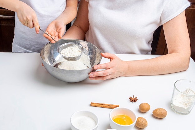 Cooking Christmas and  New Year chocolate cookies or gingerbread. Traditional festive baking, bake with kids. Step 2 sift flour through  sieve. Step by step recipe.