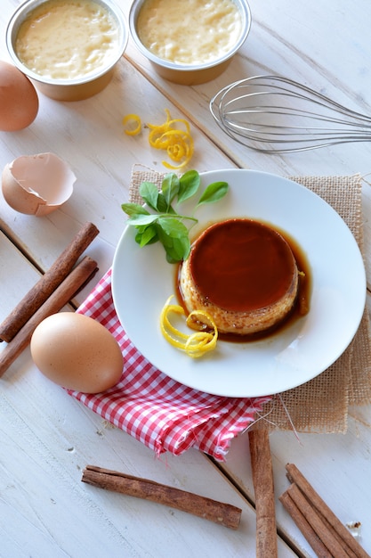 Cooking creme caramel with egg, milk, cinnamon and lemon