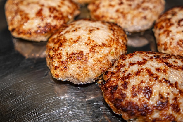 Cooking cutlets in a frying pan on an induction hob White steam is hovering over hot cutlets in a frying pan