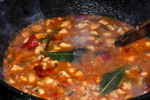 Cooking cuttlefish in american sauce on the stove of a kitchen