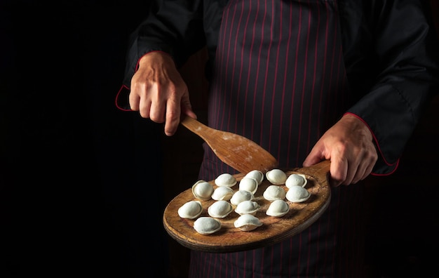 Cooking dumplings by the hands of the chef in the kitchen of the hotel Free space for advertising