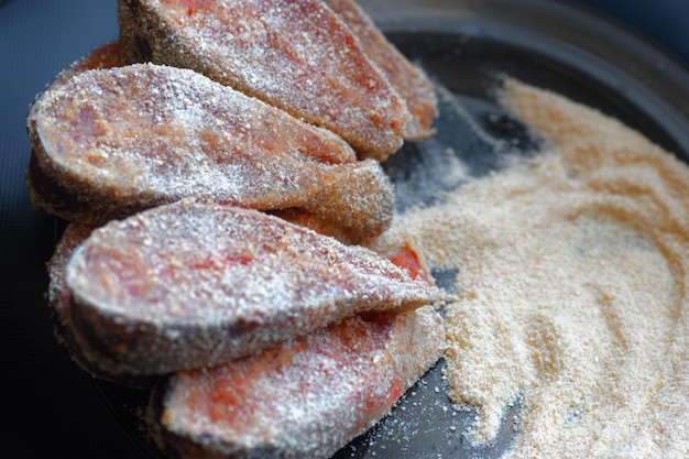 Cooking fish dishes Raw pieces of pink salmon or chum salmon in breadcrumbs are on the plate