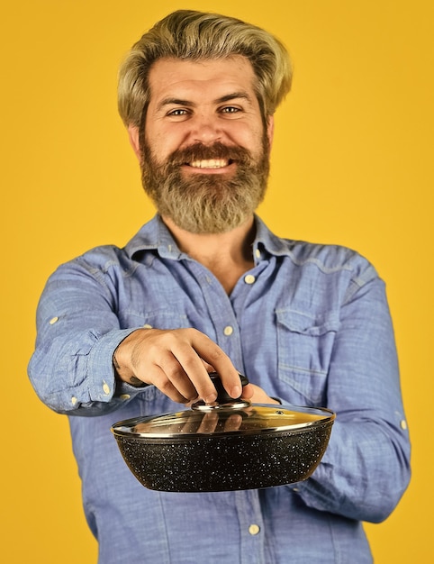 Cooking food concept Hold frying pan best quality bearded cook portrait with kitchen tools bearded man hold cooking pan cook preparing food in kitchen husband on kitchen selective focus