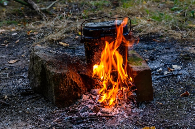 Cooking food in a kettle on bonfire in forest