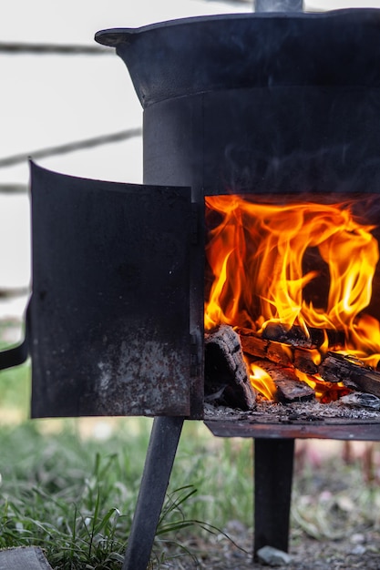 Cooking food or pilaf in a cauldron on fire Cooking in cauldron on open fire in nature