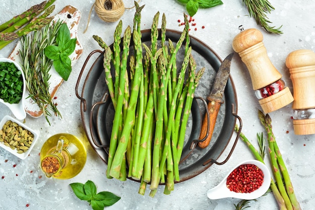 Cooking fresh green asparagus in on a stone background Healthy food Top view