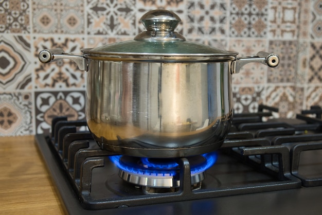 Cooking on a gas stove. The pot on gas burner. Home cooking concept.