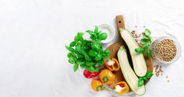 Cooking healthy food concept Zucchini, peppers, basil and lentils on white background top view