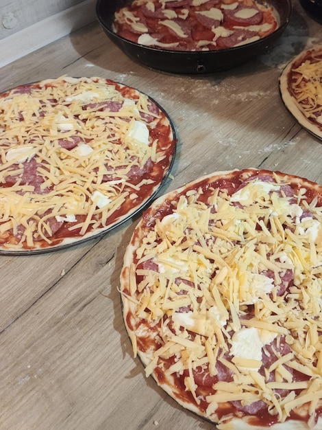 Cooking homemade pizzas on the kitchen table at home