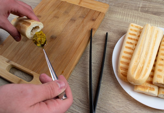 Cooking a hot dog at home on the grill, the whole process from toasting bread to folding a hot dog into one piece