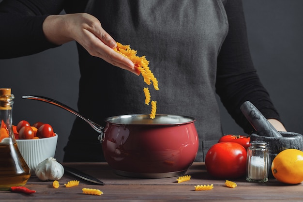 Cooking italian pasta in a pot in the kitchen.