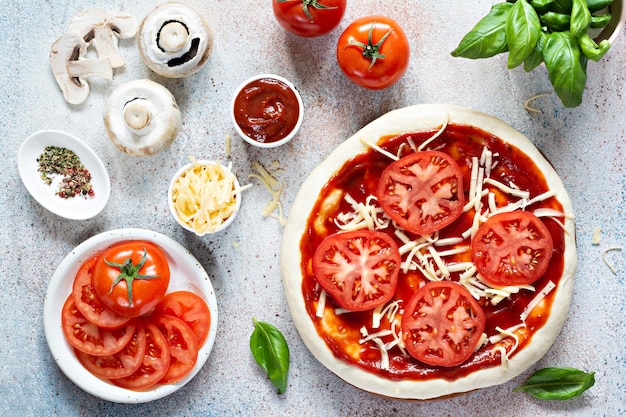 Cooking Italian pizza with tomato sauce fresh tomatoes cheese mushrooms salami slices and basil