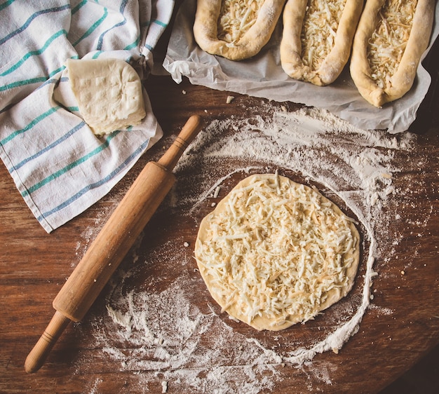 Cooking khachapuri with cheese on a table