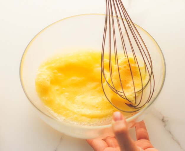 Cooking meal and diet concept  making of mixing eggs in bowl on marble table as homemade food flat lay top view food brand photography flatlay and recipe for cooking blog menu or cookbook design