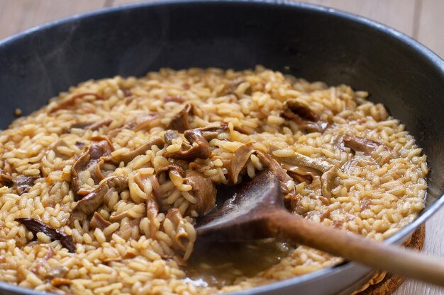 Cooking Mushroom Risotto with Wooden Spoon