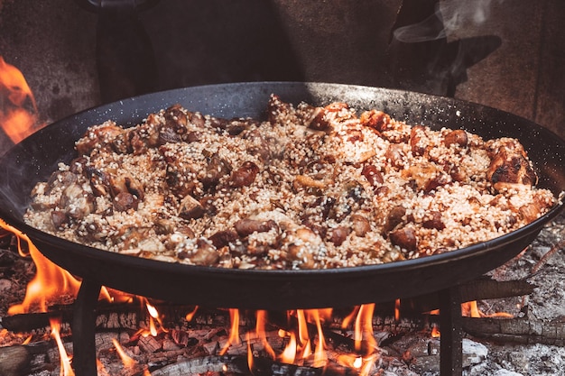 Cooking a paella rice chicken artichoke sausagesTypical Spanish food