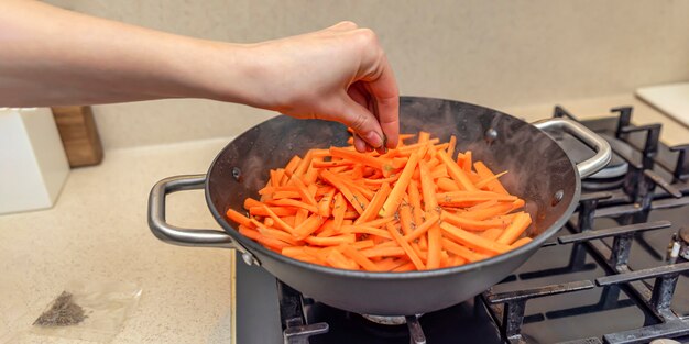 Cooking pilaf in a cauldron, a recipe for real pilaf. Sprinkle carrots with cumin, add spices to pilaf. Cooking pilaf at home.