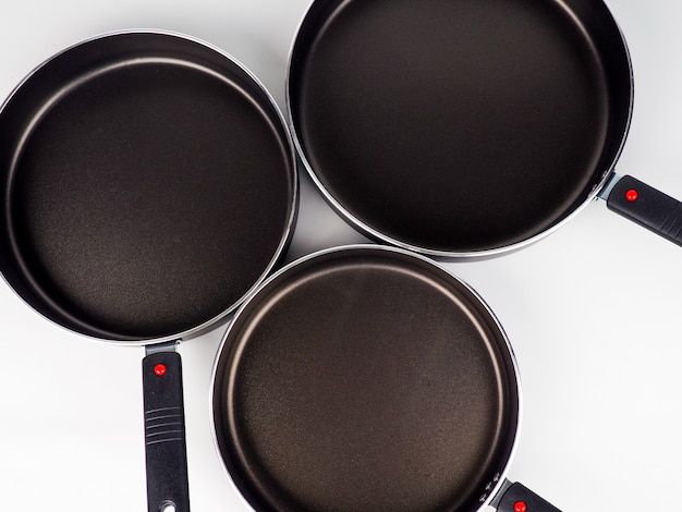 Photo cooking pot and frying pans on white surface