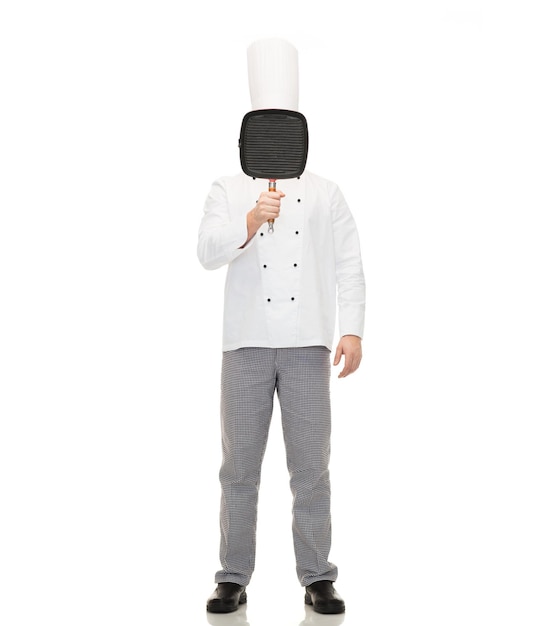 cooking, profession and people concept - male chef cook covering face or hiding behind grill pan