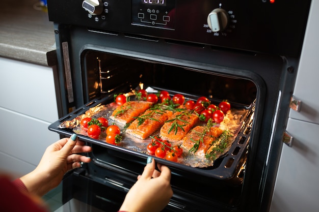 Cooking salmon in the oven. Housewife is preparing dinner. chef is cooking red fish. Cooking fish in the oven.