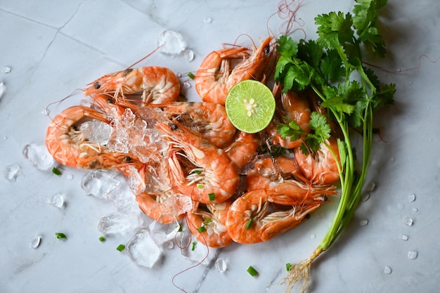 Cooking shrimp food on white plate background dining table food Fresh shrimps prawns seafood lemon lime with herbs and spice