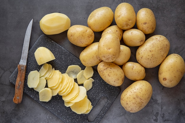 Cooking. Slicing fresh potatoes into slices on a cutting Board