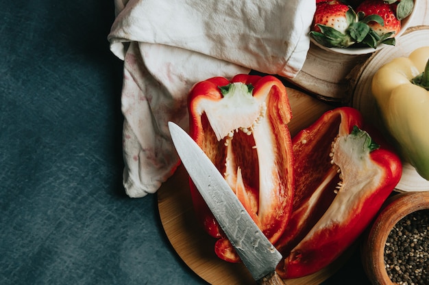 Cooking table with a pepper cut in half a knife and some condiments