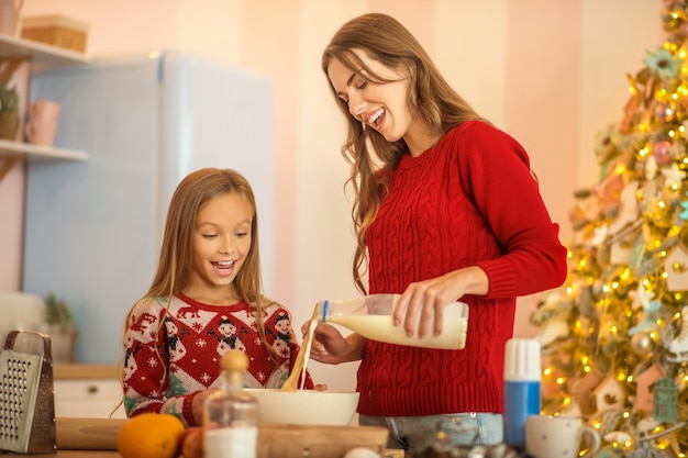 Cooking with mom. Kid and her mom cooking together in the kitchen