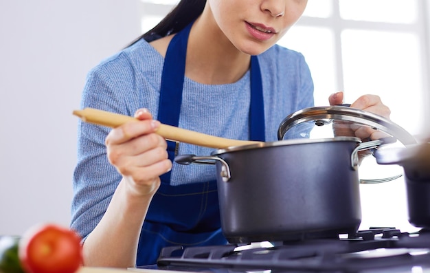 Cooking woman in kitchen with wooden spoon