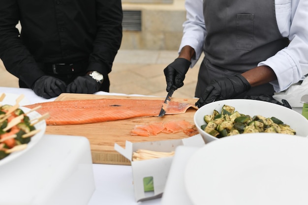 The cooks cut salmon fish at a wedding