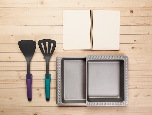 Cookware and accessories on a wooden table.