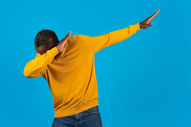 Cool african american man in casual showing moves on blue