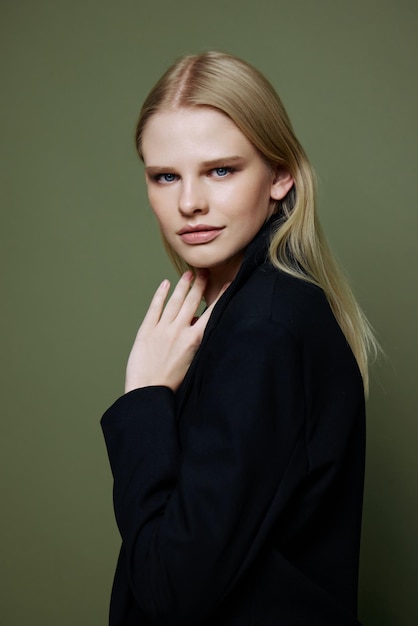 Cool banner for brands An attractive cool professional model poses in a halfturn and looks at the camera on a green olive background in the studio