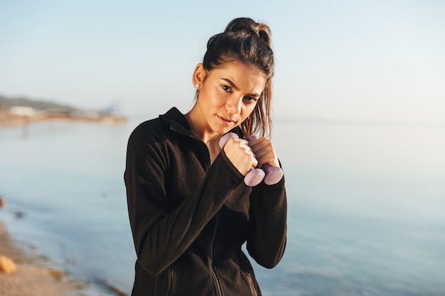 Cool sports woman doing fitness exercise with dumbbells