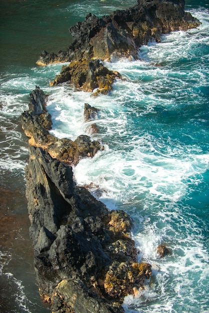 Cooled lava and ocean waves view of sea waves hitting rocks on the beach waves and rocks