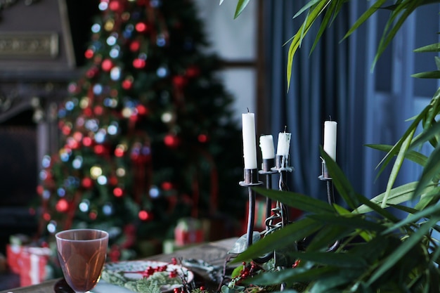 Copper, brass, metal candlestick with a white candle stands against the festive New Year background, festive atmosphere